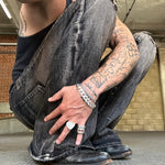 Person wearing ripped jeans and black boots in an urban setting