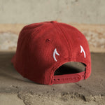 Red cord cap with embroidered horns on back